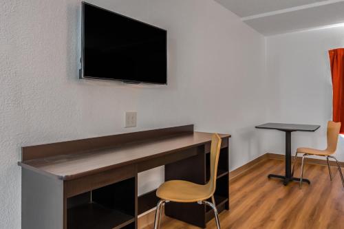 a room with a desk with a tv on a wall at Motel 6-White, GA - Cartersville in White