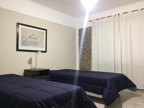 a bedroom with two beds and a window at Altos del Tala Deptos - Cabañas in Embalse