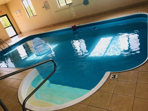a swimming pool with a chair in the middle at Pinckneyville Inn and Suites in Pinckneyville