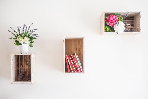 a white wall with two windows with flowers and books at Pompei Suite in Pompei