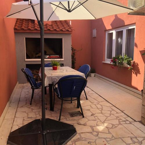 a patio with a table and chairs and an umbrella at Rooms Ana in Split