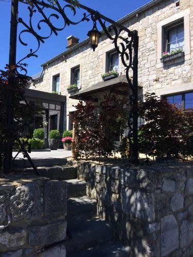 a stone building with a street light in front of it at Hotel le Fenil in Celles
