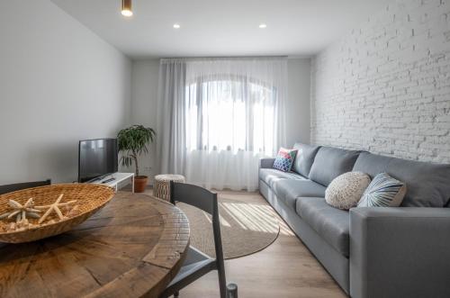 a living room with a couch and a table at Cliper Apartments by Escampa Hotels in Platja  d'Aro