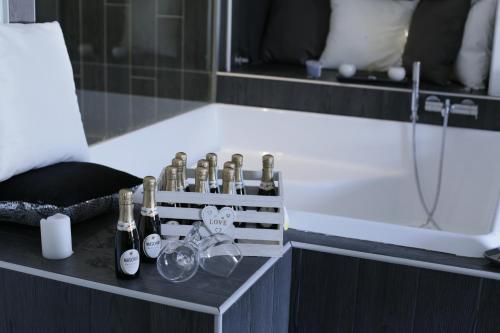 a bathroom with bottles and glasses and a tub at ESPOSITO PLAZA- ROOMS & SUITE in Naples