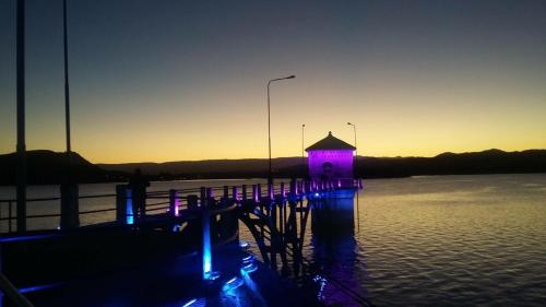 a dock with purple lights on a body of water at Altos del Tala Deptos - Cabañas in Embalse