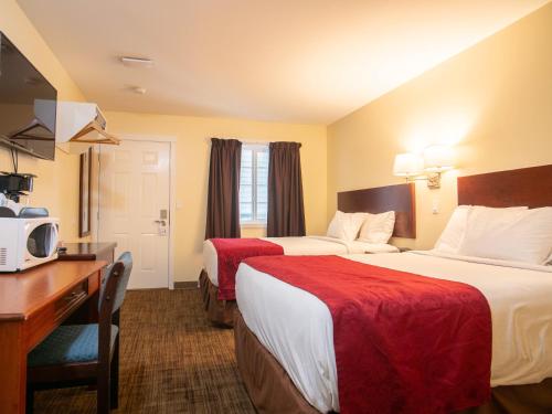 Habitación de hotel con 2 camas y escritorio en Kings Motor Inn, en Kamloops