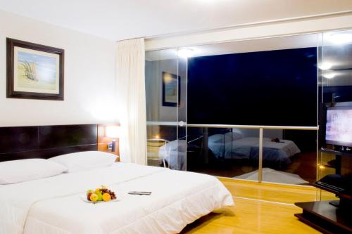a hotel room with a large bed and a television at Caballito de Totora in Huanchaco