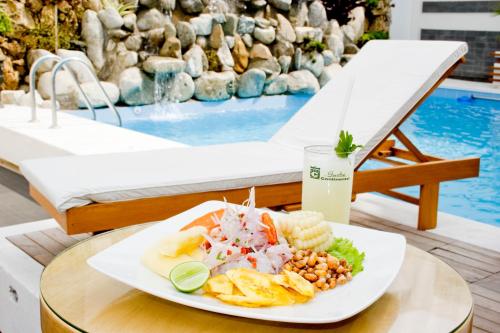 a plate of food on a table next to a pool at Caballito de Totora in Huanchaco