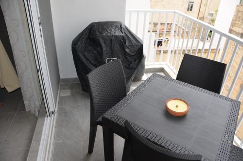 a candle sitting on a table with a trash bag at Pilgrim's Rest Apartments in Il-Gżira