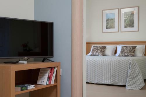 a bedroom with a bed and a flat screen tv at Hotel Estia in Finikounta