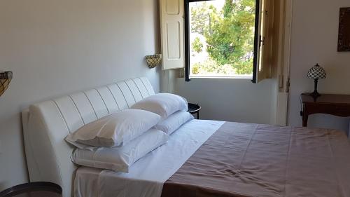a white bed with pillows on it in a bedroom at Villa Giordanelli in Scalea