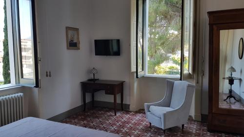 a bedroom with a bed and a chair and a desk at Villa Giordanelli in Scalea