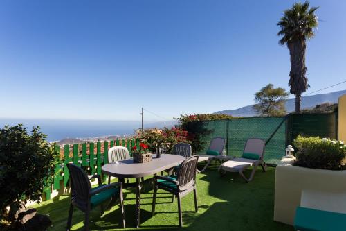 a patio with chairs and a table on the grass at Casitas La Brenda y La Gaga in Los Realejos