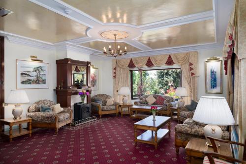 a living room with couches and a fireplace at Kathleens Country House in Killarney