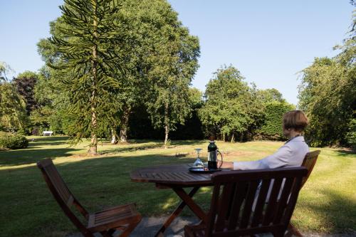 a woman sitting at a picnic table in a park at Kathleens Country House in Killarney