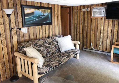sala de estar con sofá y TV en Shore Meadows Lodge LLC, en Lake George