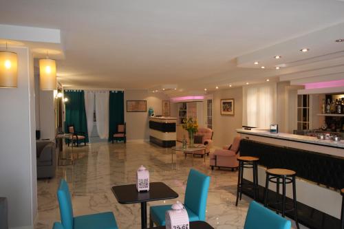 a hotel lobby with blue chairs and a bar at Hotel Naxos B&B in Alba Adriatica