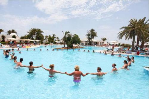 a group of people in the water at a swimming pool at El Mouradi Djerba Menzel in Midoun