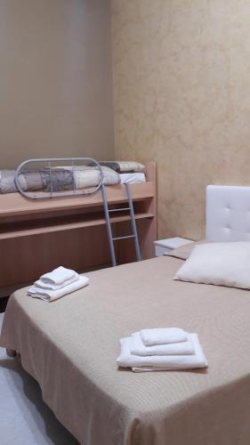 two beds in a room with towels on top of them at Vendicari in Pachino