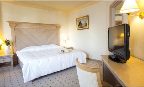 a hotel room with a bed and a flat screen tv at El Mouradi Djerba Menzel in Midoun