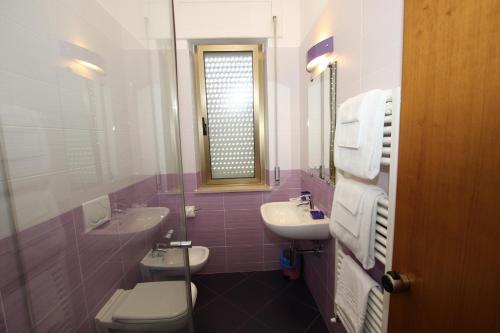 a bathroom with a sink and a toilet and a mirror at Hotel Naxos B&B in Alba Adriatica