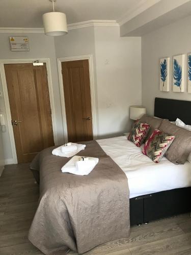 een slaapkamer met een bed met twee handdoeken erop bij Berkshire Serviced Apartment Helena 12 in Reading