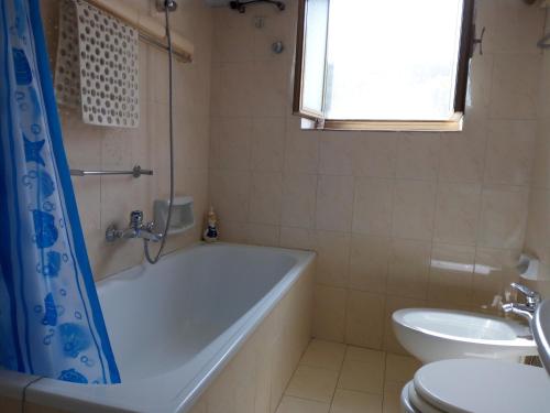 La salle de bains est pourvue d'une baignoire, de toilettes et d'un lavabo. dans l'établissement Casa Elena, à Amaroni