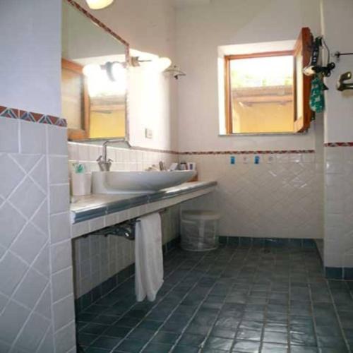 a bathroom with a sink and a mirror at la casa di titti e jack in Malfa