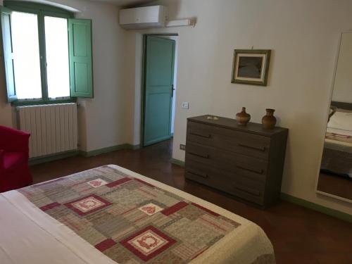 a bedroom with a bed and a dresser and a window at Appartamento Il Glicine in Pistoia