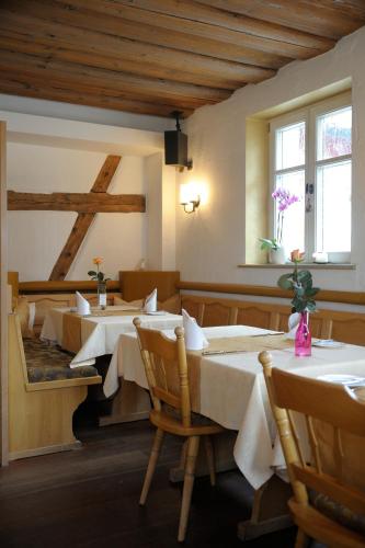 a dining room with two tables and two windows at Häusla in Dannberg