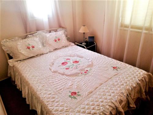 a bedroom with a white bed with flowers on it at Kalamata Downtown Apartment in Kalamata