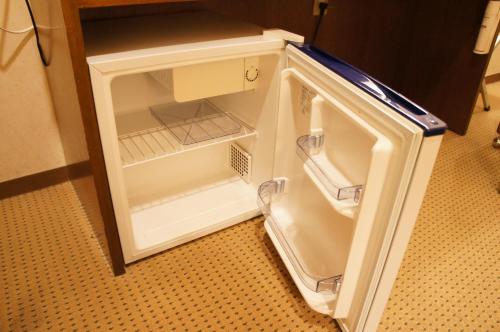 a small white refrigerator with its door open at Hotel Aisul Matsuyama in Matsuyama