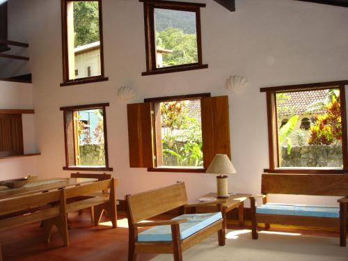 a room with a table and chairs and windows at Casa do Canto in Abraão