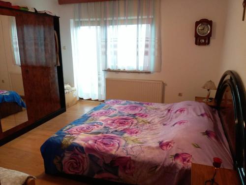 a bedroom with a bed with pink flowers on it at Kuca za odmor Sarcevic in Prozor