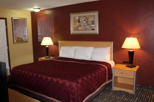 a hotel room with a bed and two lamps at The Executive Inn & Suites in Amarillo