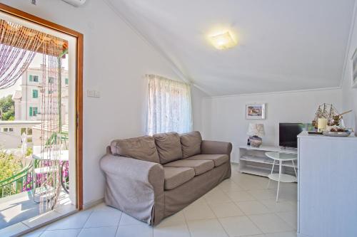 a living room with a couch and a window at House Verica in Veli Lošinj