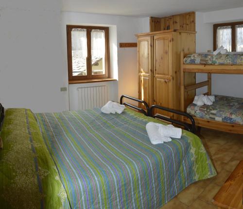 a bedroom with a bed with towels on it at Valdigiust in Campodolcino