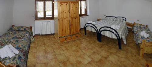 a room with two beds and a table in it at Valdigiust in Campodolcino