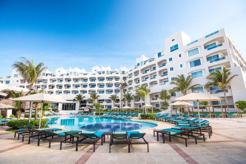 a resort with a pool and chairs and a building at Sunscape Cancun All-Inclusive Resort & Spa by Hyatt in Cancún
