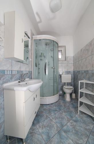 a bathroom with a shower and a sink and a toilet at Apartman Angelina in Supetar