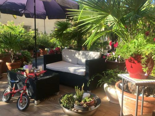 un patio con plantas, un sofá y una bicicleta en Guest House Santiago, en Arco