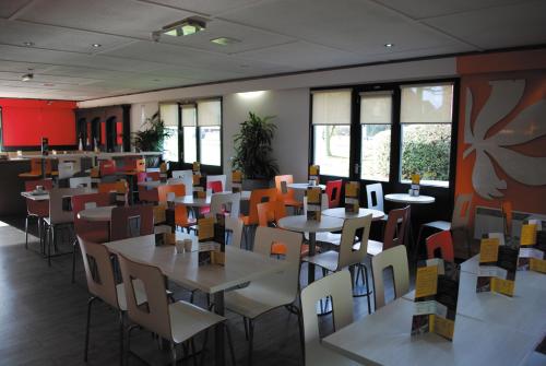 a dining room with tables and chairs and windows at The Crossway Hotel, Part of AG Collection in Coventry