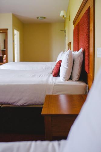 a hotel room with a bed and a wooden table at Inn On The Coast in Portrush