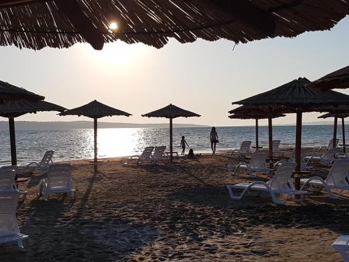 a group of chairs and umbrellas on a beach at Villa Feliks in Ljubač