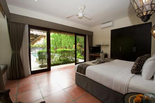 a bedroom with a bed and a large window at Villa Elleo in Seminyak