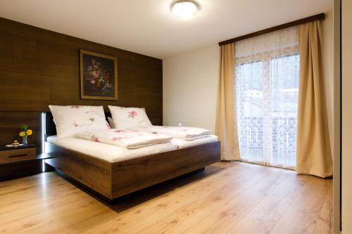 ein Schlafzimmer mit einem Bett und einem großen Fenster in der Unterkunft Apartment Am Bach in Mellau