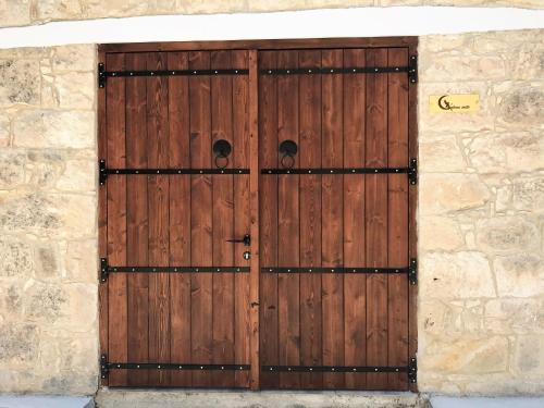 a wooden door in a stone wall with ajar at C-elena Suite in Terra