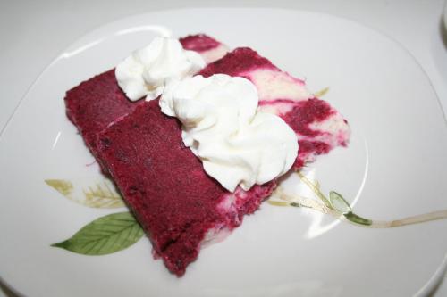 a piece of red velvet cake with whipped cream on a plate at Auberge Keur Diame in Dakar
