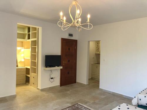 a living room with a chandelier and a bedroom at Villa Horus in Sveti Stefan