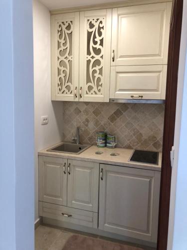 a kitchen with white cabinets and a sink at Villa Horus in Sveti Stefan